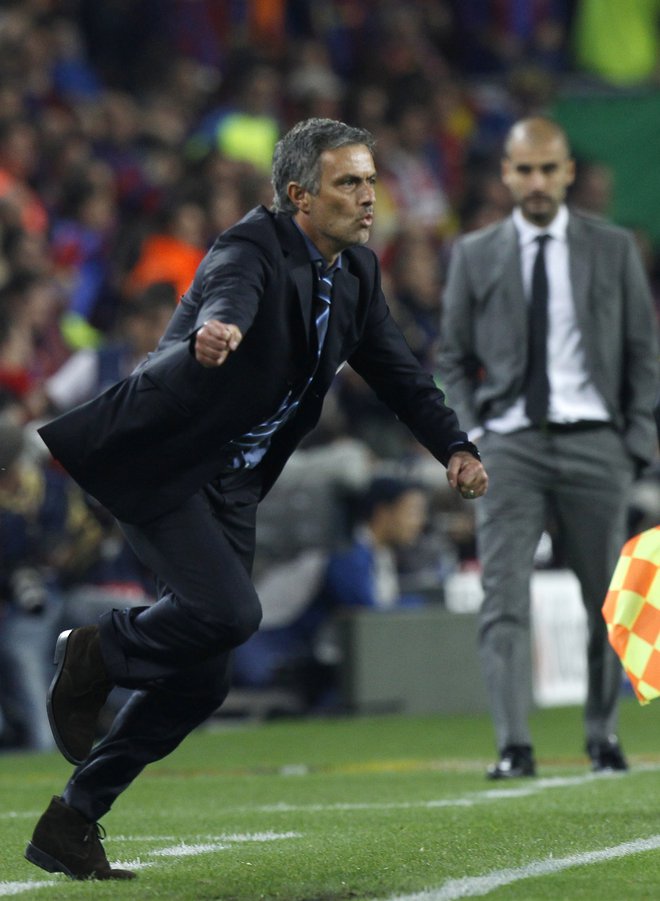 Takole se je Jose Mourinho odzval na poraz z 0:1 v Barceloni, po katerem se je z Interjem prebil v finale lige prvakov leta 2010. V ozadju ga opazuje Pep Guardiola. FOTO: Reuters
