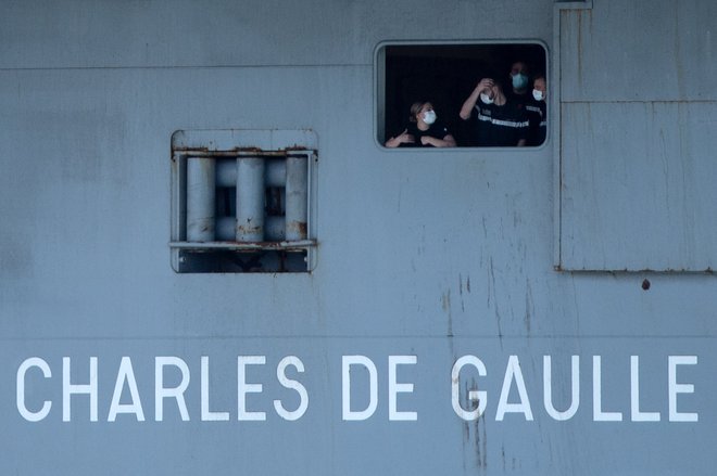 Zaradi okužbe s koronavirusom, ki so jo testi potrdili pri več kot 660 mornarjih od skupaj 1767 članov posadke, se je morala francoska letalonosilka Charles de Gaulle predčasno vrniti z misije v vzhodnem Sredozemlju. FOTO: Christophe Simon/AFP