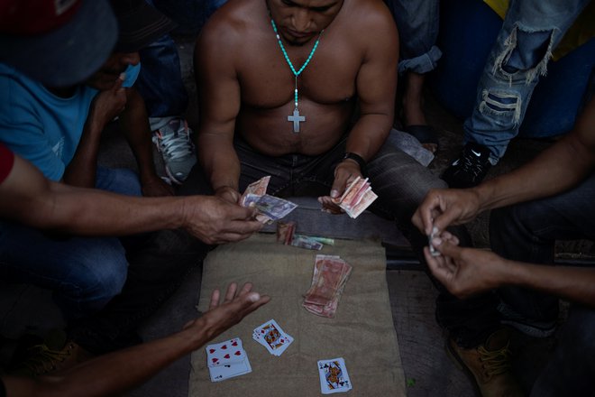 S kartami si jetniki krajšajo dneve. FOTO: Adrees Latif/Reuters