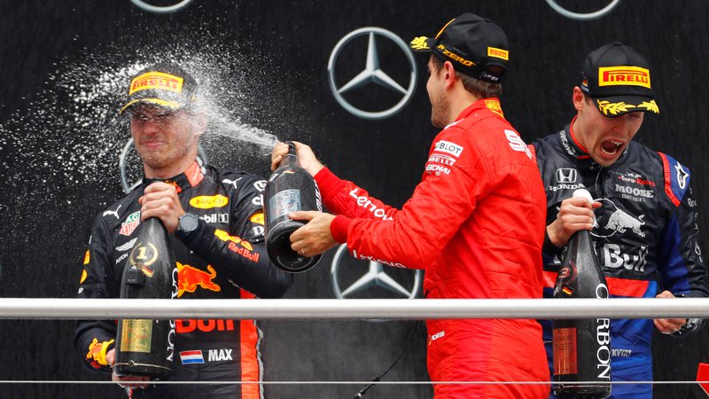 Fotografija: Drugouvrščeni Sebastian Vettel (na sredini) je s šampanjcem poškropil zmagovalca Maxa Verstappna (levo). Tretji je bil presenetljivo Rus Danil Kvjat.
Foto Reuters