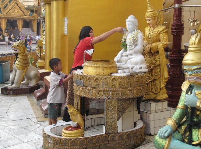 Simbolično umivanje svetih kipcev v templju Švedagon v Rangunu. FOTO: Alen Steržaj