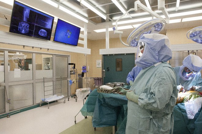 Dr. Jyrki Nieminen pregleduje pacientove medicinske slike med operacijo s preprostimi gibi roke. FOTO: Hannu Koivula