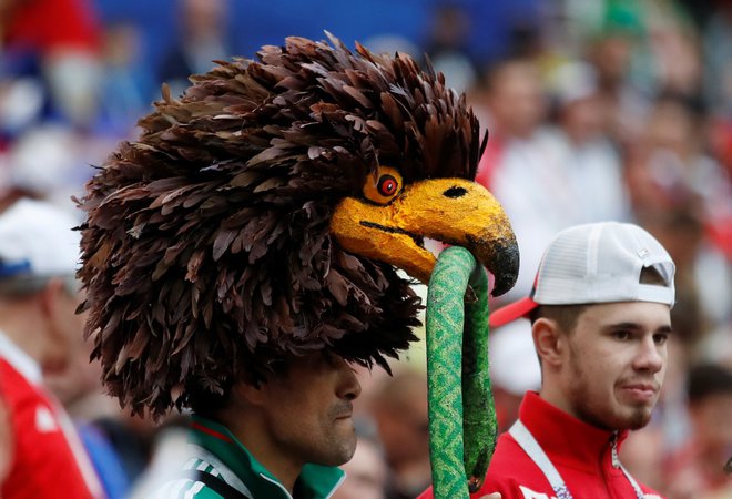 Navijač Savdske Arabije si je za otvoritveno tekmo z Rusijo za naglavno opravo izbral ptiča s kačo v kljunu. FOTO: Reuters