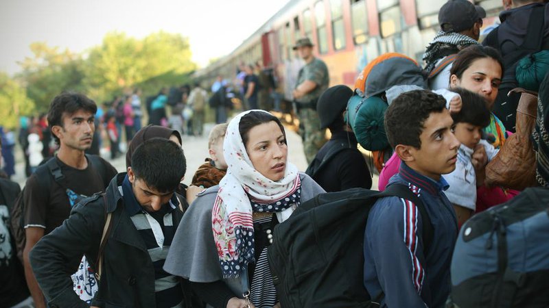 Fotografija: Begunci iz begunskega centra vstopajo na prvi jutranji vlak proti Srbiji. Gevgelija, Makedonija 28.avgusta 2015..[begunci,družine,vlaki,ženske,begunski centri]