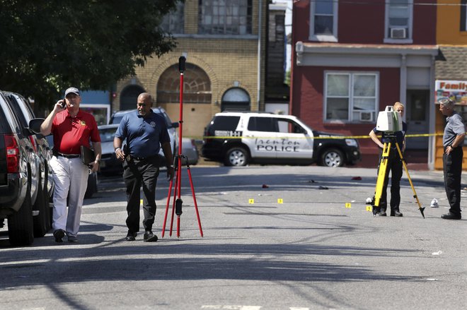 Več kot dvajset ljudi je bilo ranjenih, policija pa je preiskovala mesto zločina. FOTO: AP