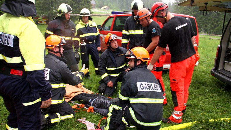 Fotografija: Gasilci in reševalci z roko v roki pomagajo poškodovanim. FOTO: Jože Miklavc