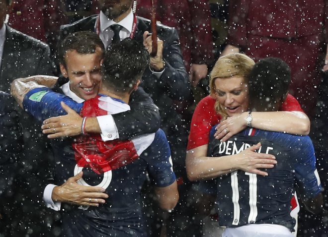 Macron in Grabar Kitarovićeva objemata igralce. FOTO: Rebecca Blackwell/AP