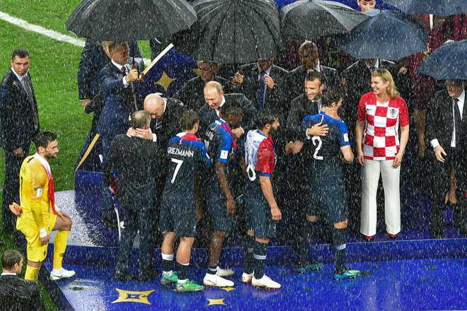 V resnici so dežnike ponudili vsem politikom in funkcionarjem, toda mnogi so potem raje stali na dežju. FOTO: AFP