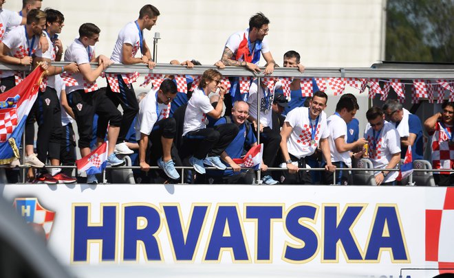 Hrvaški srebrni nogometaši poskrbeli za slavje, ki ga Hrvaška ne pomni. Avtobus se še naprej prebija proti osrednjem zagrebškem trgu. FOTO: Attila Kisbenedek/AFP