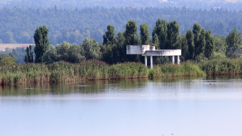 Fotografija: Jezero nad odlagališčem nenevarnih odpadkov in pregrado Cinkarne Celje v Bukovžlaku, desno vrh spomenika v Parku spomina Teharje. FOTO: Brane Piano