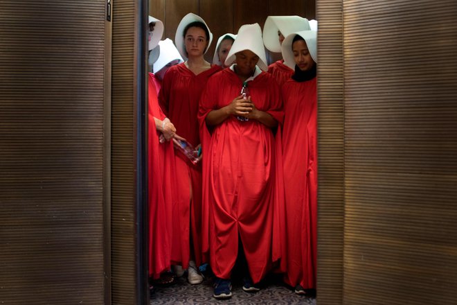 Ženske, oblečene v kostume iz Dekline zgodbe, protestirajo pred sodiščem proti imenovanju Kavanaugha. FOTO: Jim Watson/Afp