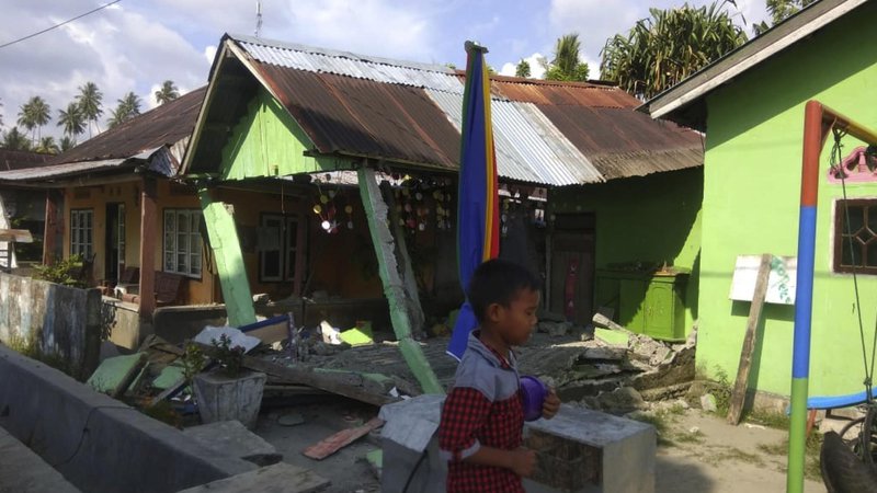 Fotografija: Indonezijska agencija za nesreče poroča o zrušenih objektih, cunami z 1,5 metra visokimi valovi je odnašal hiše. FOTO: AFP