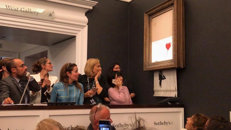 Fotografija: Trenutek po dražbi, na kateri je Banksyjevo Deklico z balonom doletel razrez. Fotografije Instagram