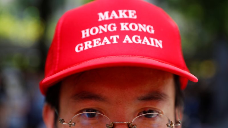 Fotografija: Številni hongkonški aktivisti te dni nosijo rdeče kape s ščitnikom in napisom »Naredimo Hongkong znova velik!«. FOTO: Kai Pfaffenbach/Reuters