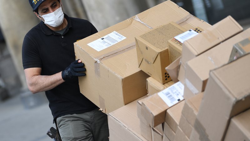 Fotografija: Tudi čezmejni spletni nakupi z dostavo na dom so v času korone močno narasli.  FOTO: Andreas Gebert/Reuters