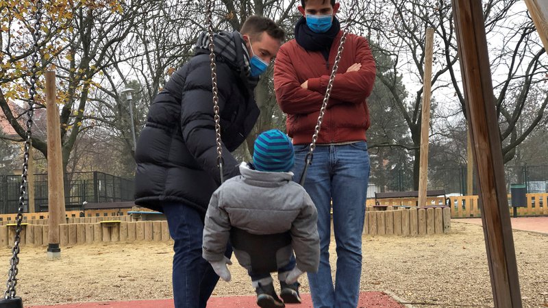 Fotografija: Istospolni par s posvojenim sinom na igrišču v Budinpešti. FOTO: Krisztina Frnyo/Reuters