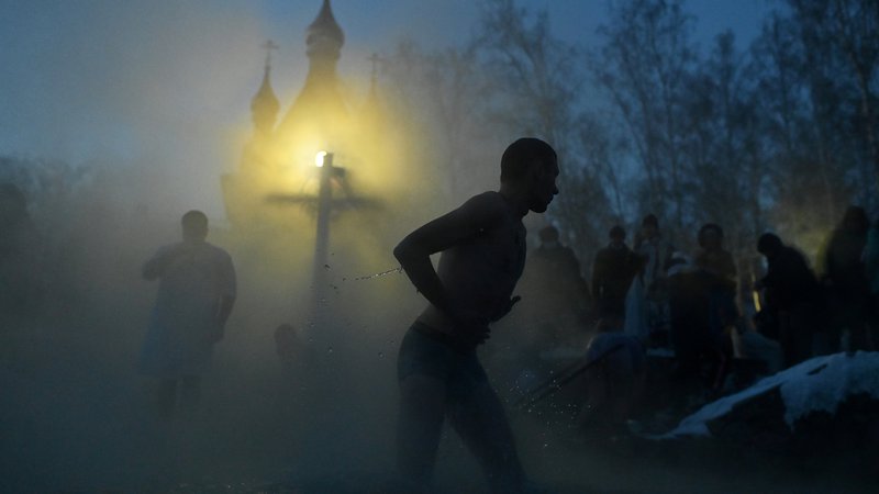 Fotografija: Utrinek iz ruskega mesta Omsk med potopom v mrzlo reko med praznovanjem pravoslavnega praznika Svetih treh kraljev. Verjamejo, da blagoslovljena mrzla voda očisti grehov tako njihovo telo kot duha. FOTO: Alexey Malgavko/Reuters