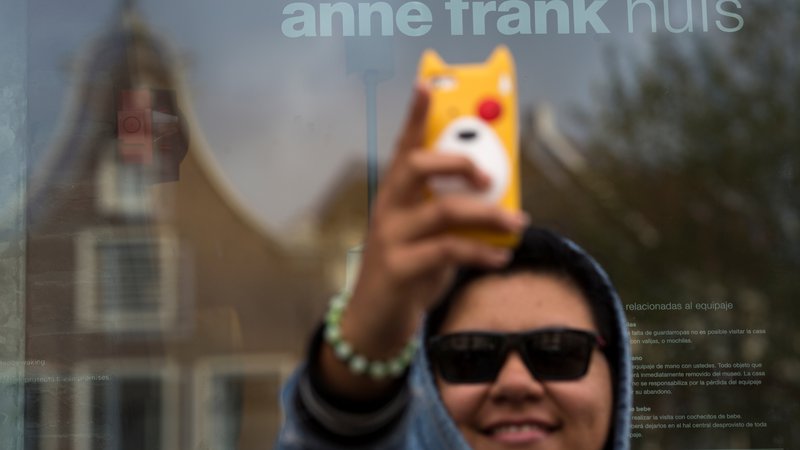 Fotografija: Selfi pred hišo, v kateri se je skrivala Ana Frank. FOTO: Cris Toala Olivares/Reuters
