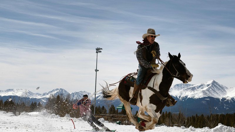 Fotografija: Domačini in obiskovalci so se minuli konec tedna zbrali v ameriškem gorskem mestecu Leadville na 73. različici tekmovanja Leadville Skijoring, ki se vsako leto odvija po glavni aveniji Harrison. Skijoring je poseben zimski šport, pri katerem eno osebo na smučeh vleče konj, pes ali celo motorne sani. Gre za rekreativni in tudi tekmovalni šport, ki združuje smučanje in konjeništvo.
FOTO: Jason Connolly/Afp