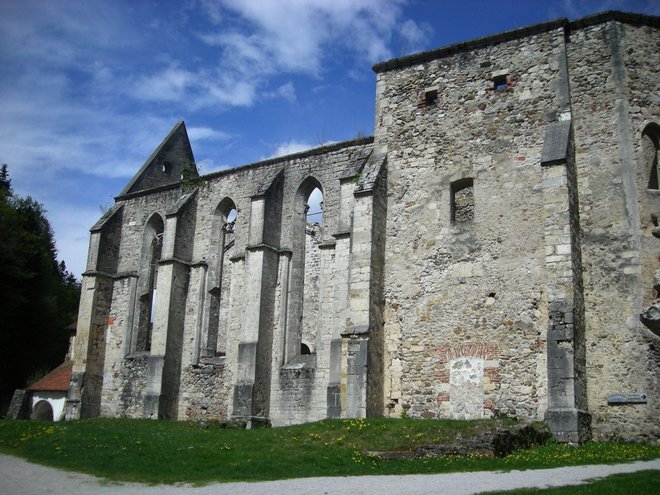 Sedanja gotska cerkev sv. Janeza Krstnika je rezultat nadzidav in preoblikovanj prvotne romanske stavbe. Cesar Jožef II. je z ediktom leta 1782 samostan ukinil, to dejanje pa je sprožilo nezadržen propad stavb v zgornjem samostanu. Foto Drago Medved