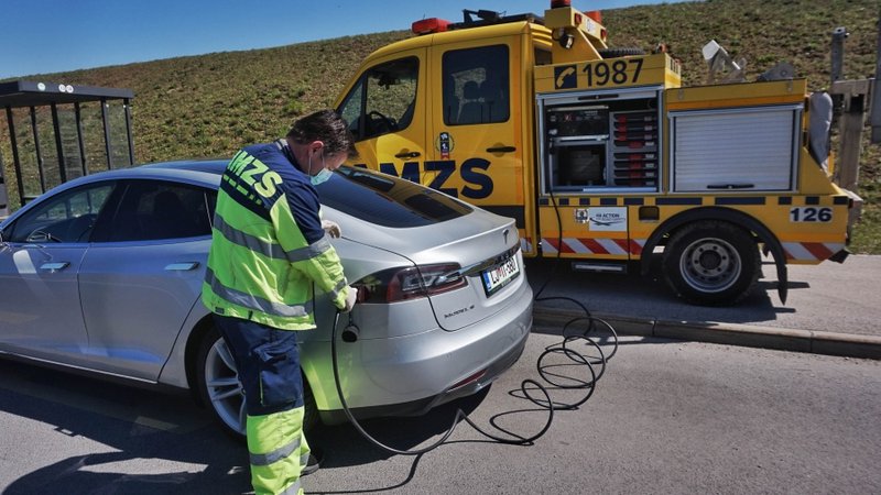 Fotografija: Če se na poti izprazni baterija e-vozila, na pomoč lahko priskoči AMZS z mobilno polnilnico. FOTO: AMZS