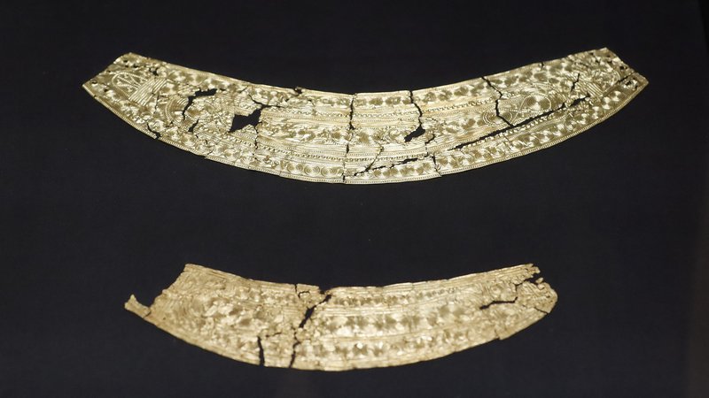 Fotografija: Mojstrsko izdelana našitka iz 13. ali 12. st. pr. n. št., ki so ju našli na obrežju Blejskega jezera, sta najstarejša zlata predmeta, najdena na slovenskem ozemlju. O motiviki, večplastni simboliki sonca in lune, so napisane številne razprave. FOTO: Leon Vidic