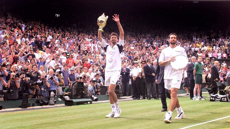 Fotografija: V zgodovini Wimbledona je Ivanišević (levo) postal drugi nepostavljeni igralec, ki je zmagal. Pred tem je podoben podvig uspel le Borisu Beckerju leta 1985. FOTO: Ian Waldie/Reuters
