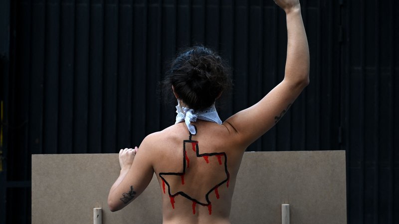 Fotografija: Članica aktivistične skupine Femen z narisano ameriško zvezno državo Teksas na hrbtu, je pred ameriškim konzulatom v Madridu protestirala proti novemu zakonu o splavu v Teksasu. Teksaški guverner je pohvalil nov zakon o splavu, ki zaostruje zakon o zdravilih, ki povzročajo splav. To ustvarja dodatne omejitve po skoraj popolni prepovedi splava. Nove omejitve, ki začnejo veljati decembra 2021, skrajšajo čas, ko lahko zdravniki v Teksasu predpišejo zdravila, ki povzročajo splav in prepoveduje dostavo tablet po pošti. FOTO: Gabriel Bouys/Afp
 