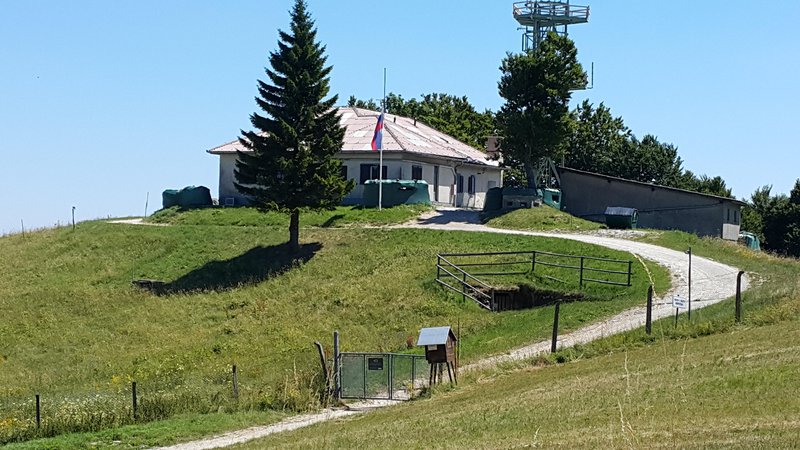 Fotografija: Ob vojaškem objektu na Trdinovem vrhu še vedno plapola slovenska zastava, čeprav je vojašnica po arbitražni razsodbi na ozemlju sosednje Hrvaške.  FOTO: Bojan Rajšek/Delo
