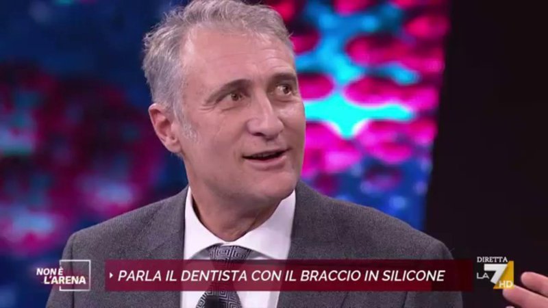 Fotografija: Zobozdravnik Guido Russo je v televizijski oddaji razkril, da se je dan po goljufiji z roko iz silikona tudi zares cepil, a zato, ker je v to prisiljen. FOTO: zajem zaslona televizijske oddaje na La7

