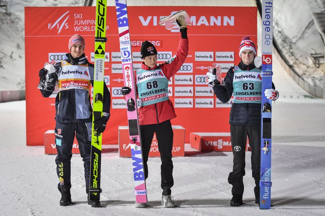 Japonskemu zvezdniku Rjojuju Kobajašiju (na sredini), ki je včeraj slavil tretjo zmago v sezoni in skupno 22. v svetovnem pokalu, sta družbo na odru za najboljše delala drugouvrščeni Nemec Karl Geiger (levo) in tretjeuvrščeni Norvežan Marius Lindvik (desno). FOTO: Fabrice Coffrini/AFP
