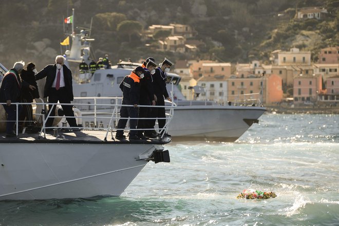 Častniki italijanske obalne straže so danes na mestu nasedle Concordie v morje vrgli venec in se ob desetletnici nesreče  poklonili spominu na 32 žrtev. FOTO: Filippo Monteforte/AFP
