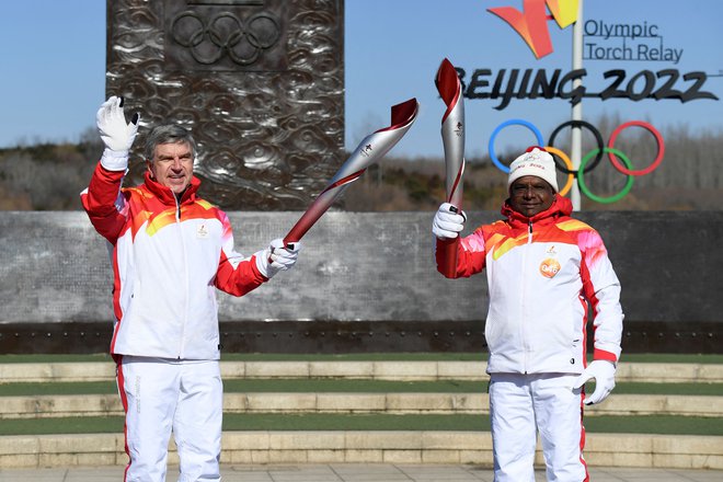 Thomas Bach, predsednik Mednarodnega olimpijskega komiteja, si je plamen v Pekingu »podal« s predsednikom generalne skupščine Združenih narodov Abdullo Shahidom. FOTO: Wang Zhao/AFP
