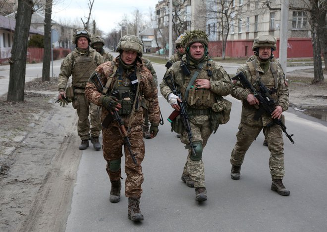 Uslužbenci ukrajinskih vojaških sil se sprehajajo po majhnem mestu Severodoneck v regiji Doneck. FOTO: Anatolii Stepanov/AFP
