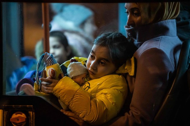 Mati s hčerko po begu iz Ukrajine na avtobusu na avtobusni postaji v Bukarešti. Tudi Romunija je cilj beguncev iz Ukrajine, na njenih mejah je manj gneče in čakanja kot na ukrajinsko-poljski meji. FOTO: Mihai Barbu/AFP
