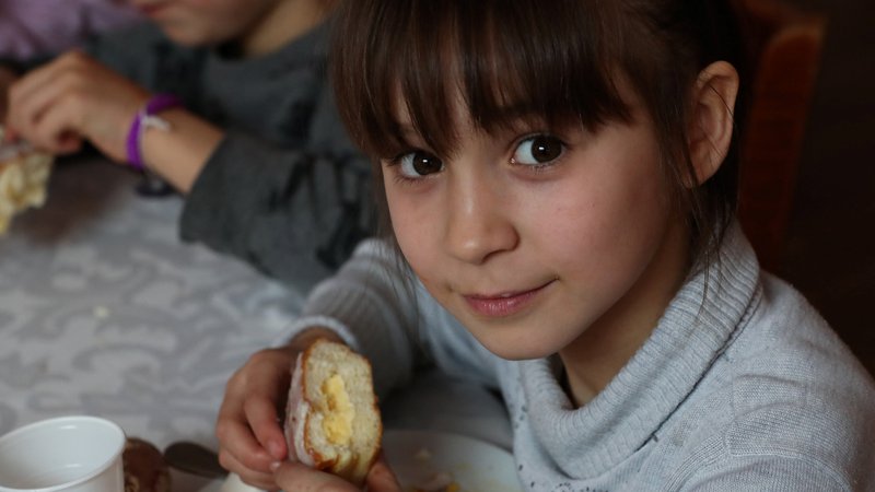 Fotografija: Osemletna deklica Sonia je skupaj z drugimi otroci iz sirotišnice našla zavetje na Poljskem. FOTO: Kacper Pempel/Reuters
