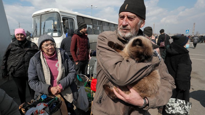 Fotografija: Moški z mačko in drugi begunci pred evakuacijo iz obleganega Mariupolja 5. aprila. FOTO: Alexander Ermochenko/Reuters
