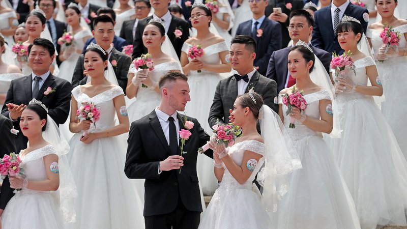 Fotografija: Na Kitajskem občasno izvedejo skupinske poroke, a urbani milenijci najraje ostajajo v neformalnih zvezah, predvsem ženske pa kariero postavljajo pred zakon. FOTO: Reuters
