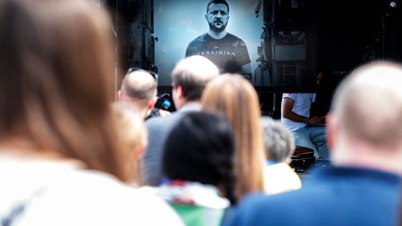 Fotografija: Udeleženci protivojnih protestov na Dunaju so si na velikem zaslonu ogledali govor ukrajinskega predsednika Volodimirja Zelenskega. Foto: Joe Klamar/AFP
