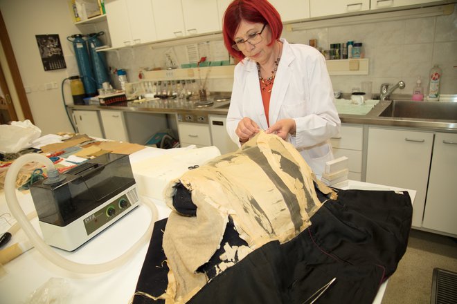 Restavratorka in konservatorka Marina Čurin iz Pokrajinskega muzeja Ptuj Ormož je stabilizirala in konservirala zelo krhko svileno podlogo uniforme. Fotografije arhiv NMS
