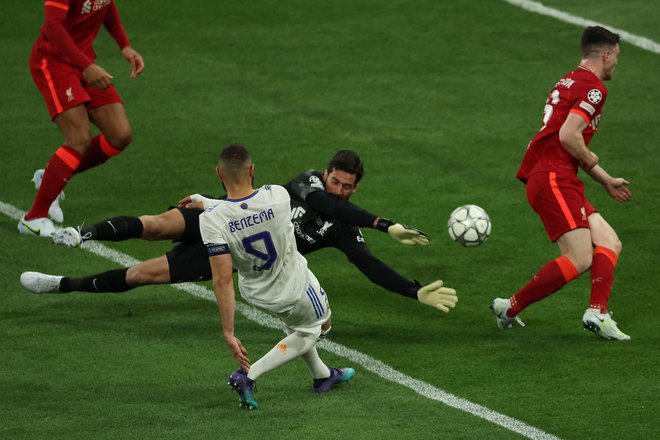 Karim Benzema je izkoristil neodločno posredovanje obrambe Liverpoola in poslal žogo mimo vratarja Alissona Beckerja, nato so po več kot dveh minutah pregledovanja posnetkov sodniki v VAR-sobi sporočili, da zadetek ne bo obveljal. FOTO: Thomas Coex/AFP
