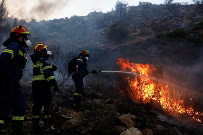 Gasilci in prostovoljci se borijo z ognjem. FOTO: Costas Baltas/Reuters
