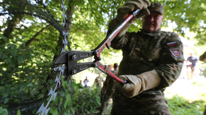 Fotografija: Danes je dvanajst pripadnikov Slovenske vojske odstranilo prve metre žice na meji. FOTO: Dejan Javornik/Slovenske novice
