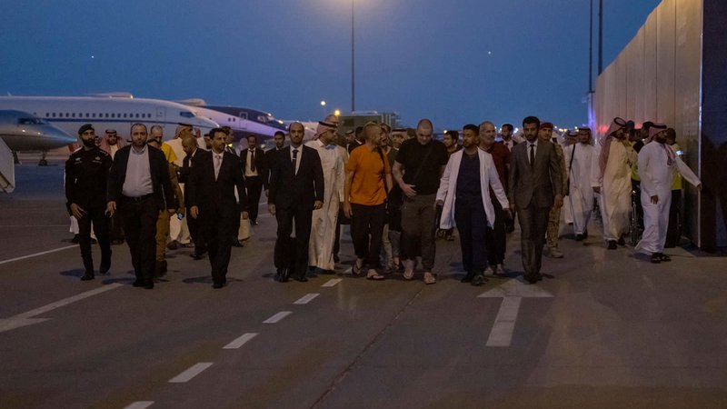 Fotografija: Vojni ujetniki, ki prihajajo iz ZDA, Maroka, Švedske, Hrvaške in Velike Britanije, so v savdsko prestolnico Rijad prispeli iz Rusije. FOTO: Saudi Press Agency via Reuters
