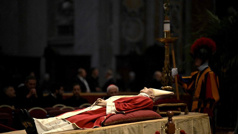 Fotografija: Posmrtni ostanki papeža Benedikta XVI. od včeraj ležijo v baziliki svetega Petra, kjer bo v četrtek vodil pogrebne slovesnosti njegov naslednik Frančišek. FOTO: Tiziana Fabi/AFP
