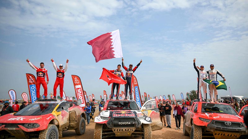 Fotografija: Toyotin katarski voznik Nasser al-Attiyah se je takole veselil zmage s sodelavci. FOTO: Franck Fife/AFP
