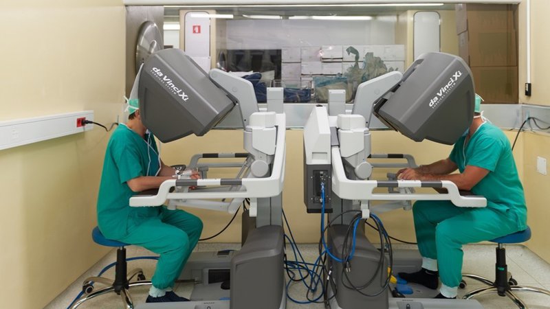 Fotografija: Kirurg na ekranu vidi desetkrat povečano tridimenzionalno sliko tkiva, skalpel pa vodi prek konzole, kar mu omogoča bolj natančne reze.

Foto Arhiv UKC Ljubljana

