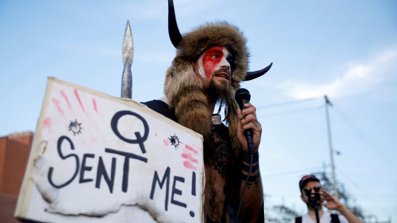 Fotografija: Vzdevek samooklicanega šamana se nanaša na teorijo zarote, katere privrženci menijo, da je nekdanji predsednik Trump vodil skrivno vojno proti elitnim pedofilom, ki častijo satana. FOTO: Cheney Orr/Reuters