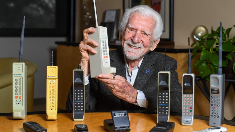 Fotografija: Inženir Martin Cooper s kopijo telefona, ki ga je izumil in prvič uporabil pred natanko 50 leti. FOTO: Valerie Macon/AFP