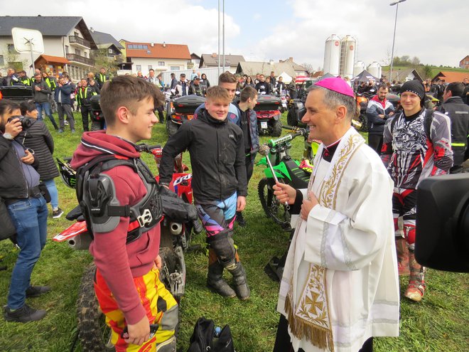 Škof Andrej Saje med kratkim pogovorom z mladim motoristom. FOTO: Bojan Rajšek/Delo